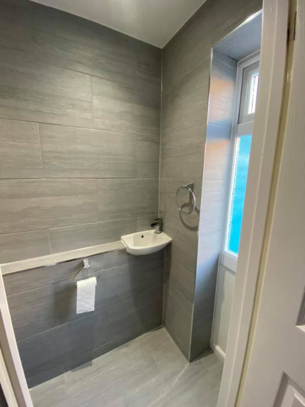 View through the doorway of the bathroom showing another small sink