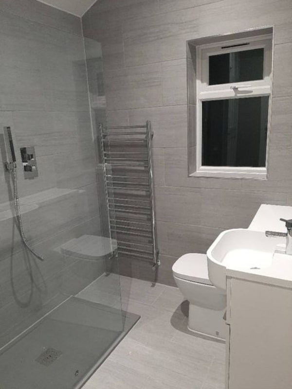 Shot of Nicole's bathroom with sink unit on the right side leading to the walk-in shower on the left.