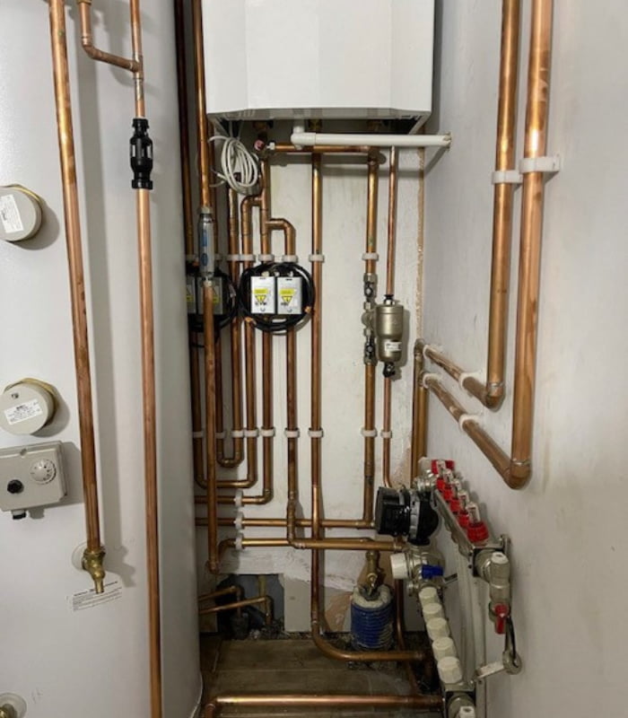 Close-up of the pipe work under a new boiler install