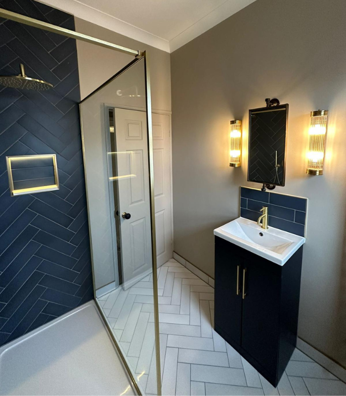 Finished bathroom project with white tiled floor and contrasting blue tiled shower wall